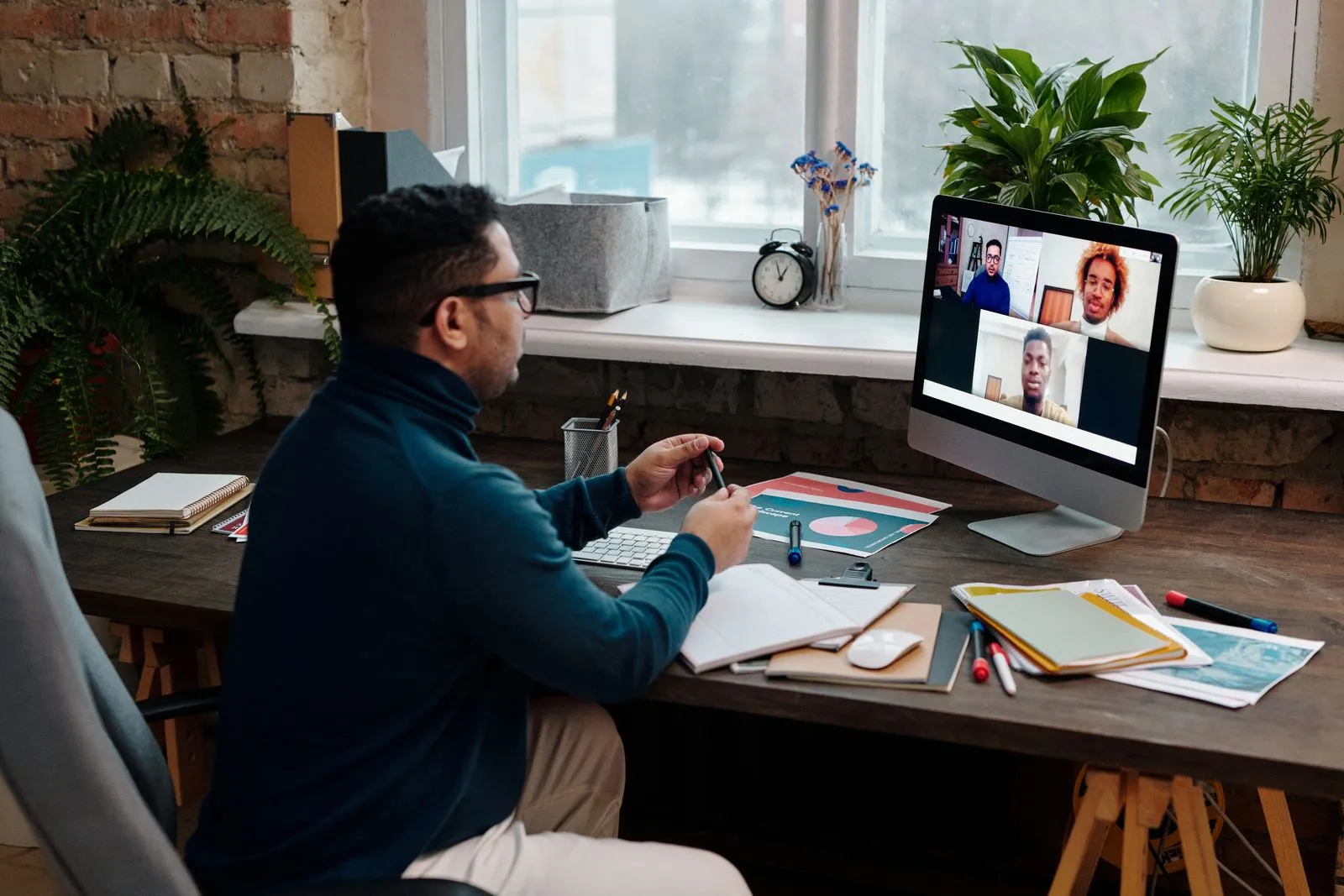 A teacher working at a laptop in a home office